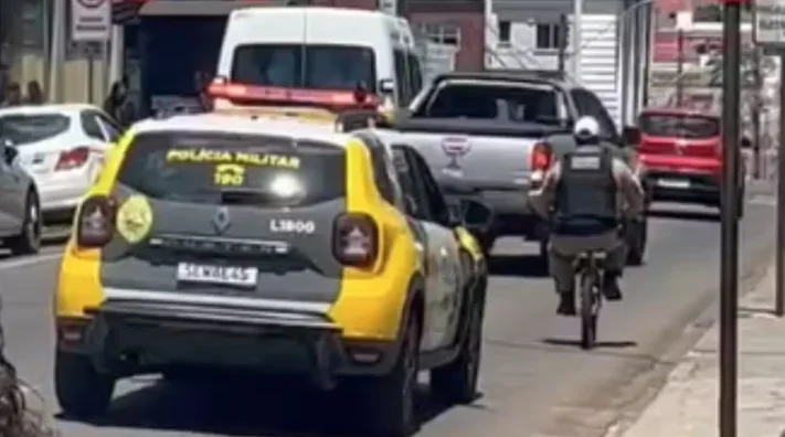  Policial Militar leva ‘mini’ bicicleta apreendida para delegacia pedalando ao lado de viatura